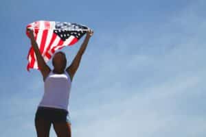 woman holding american flag above head
